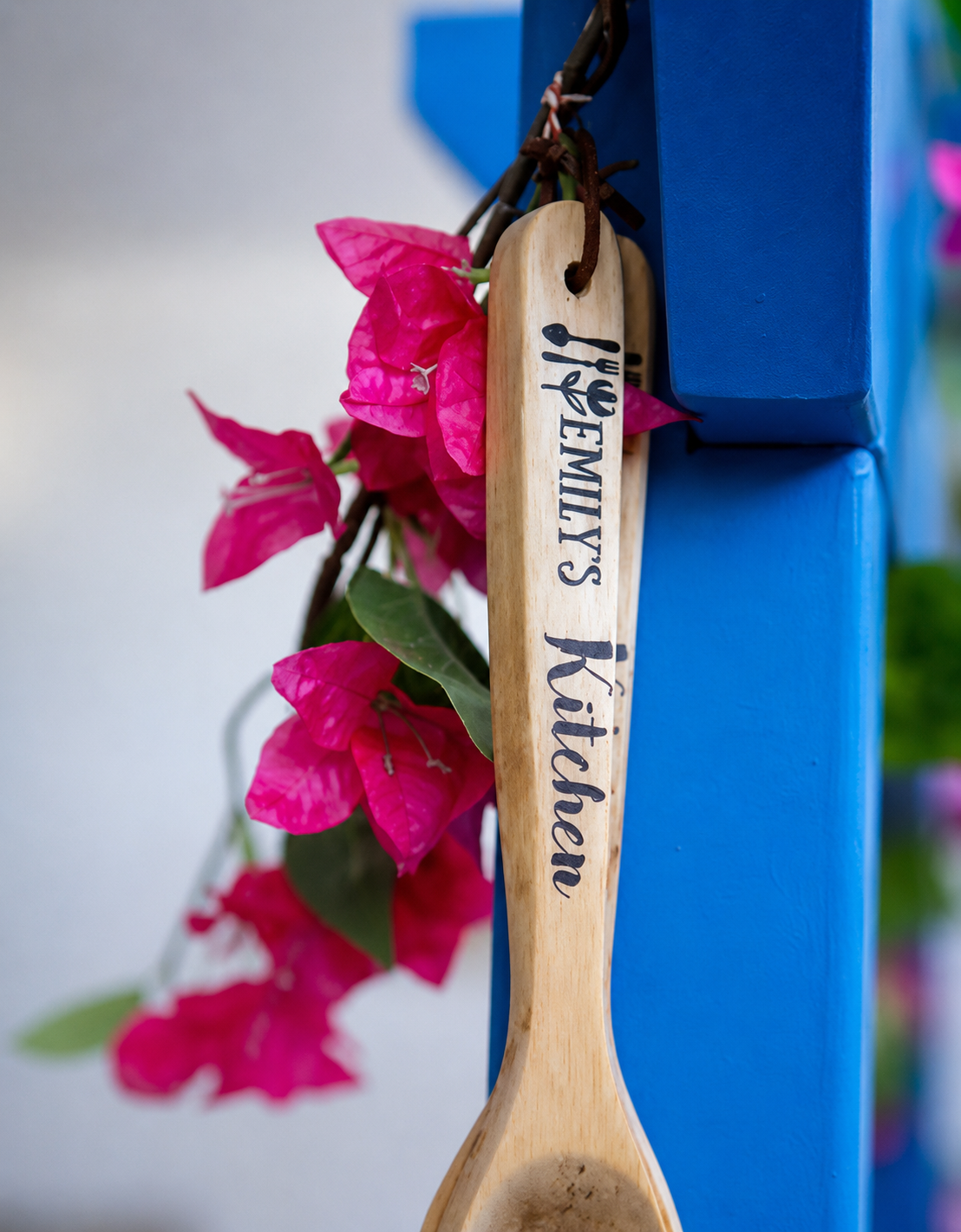 Wooden spoon with 'Emily's Kitchen' engraving against a colorful background